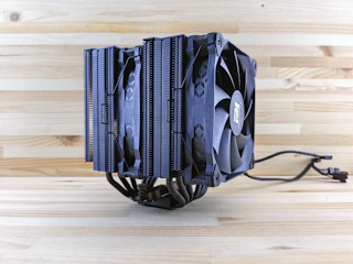 A powerful CPU cooler with sleek fins and a glowing fan in a dark environment.