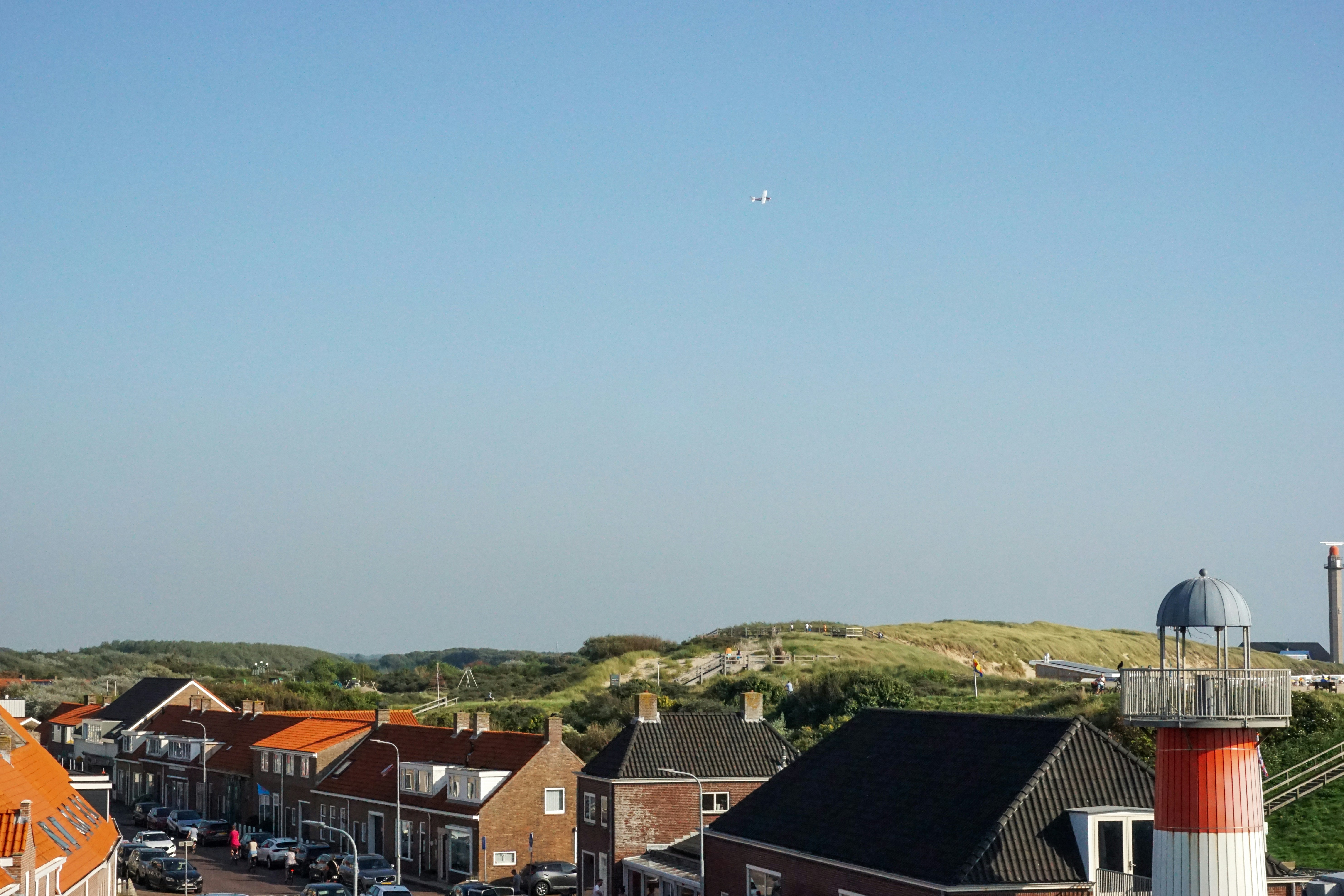 Blick auf eine Stadt mit einem Flugzeug, das am Himmel fliegt