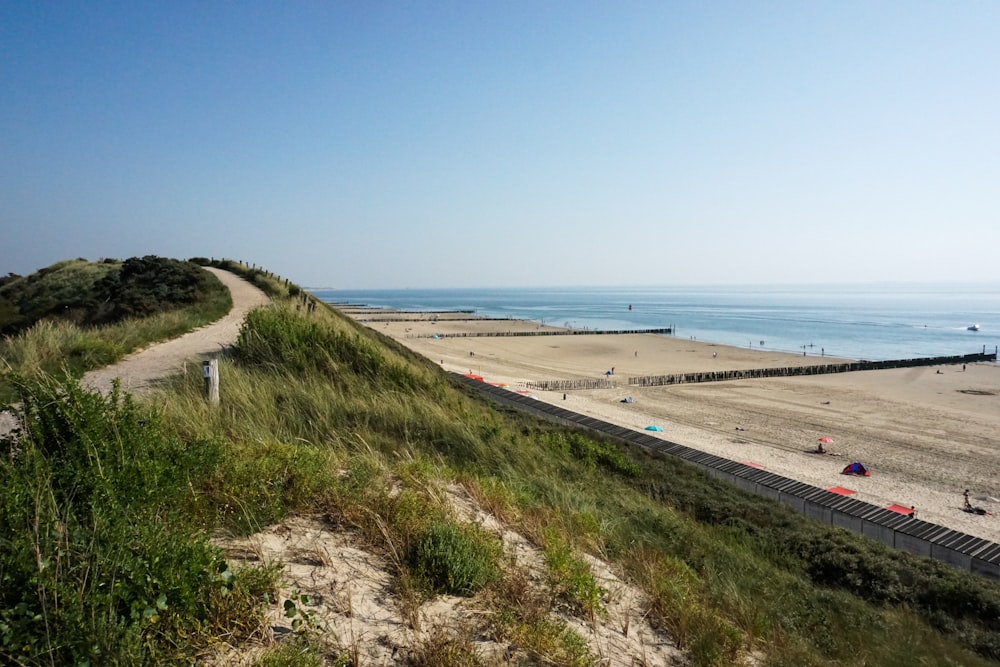 a sandy beach next to a body of water