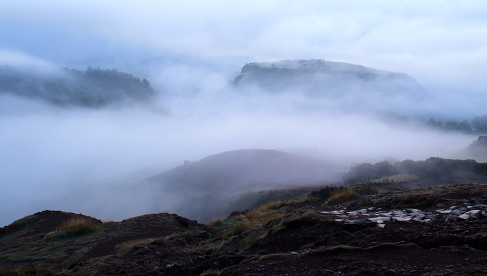 a foggy mountain landscape with low lying clouds