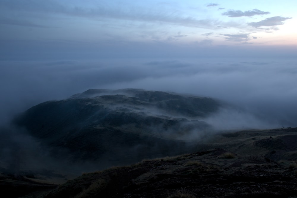 a mountain covered in fog and low lying clouds