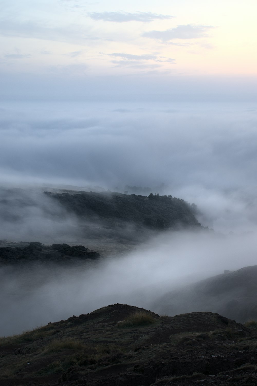 a hill covered in fog and low lying clouds