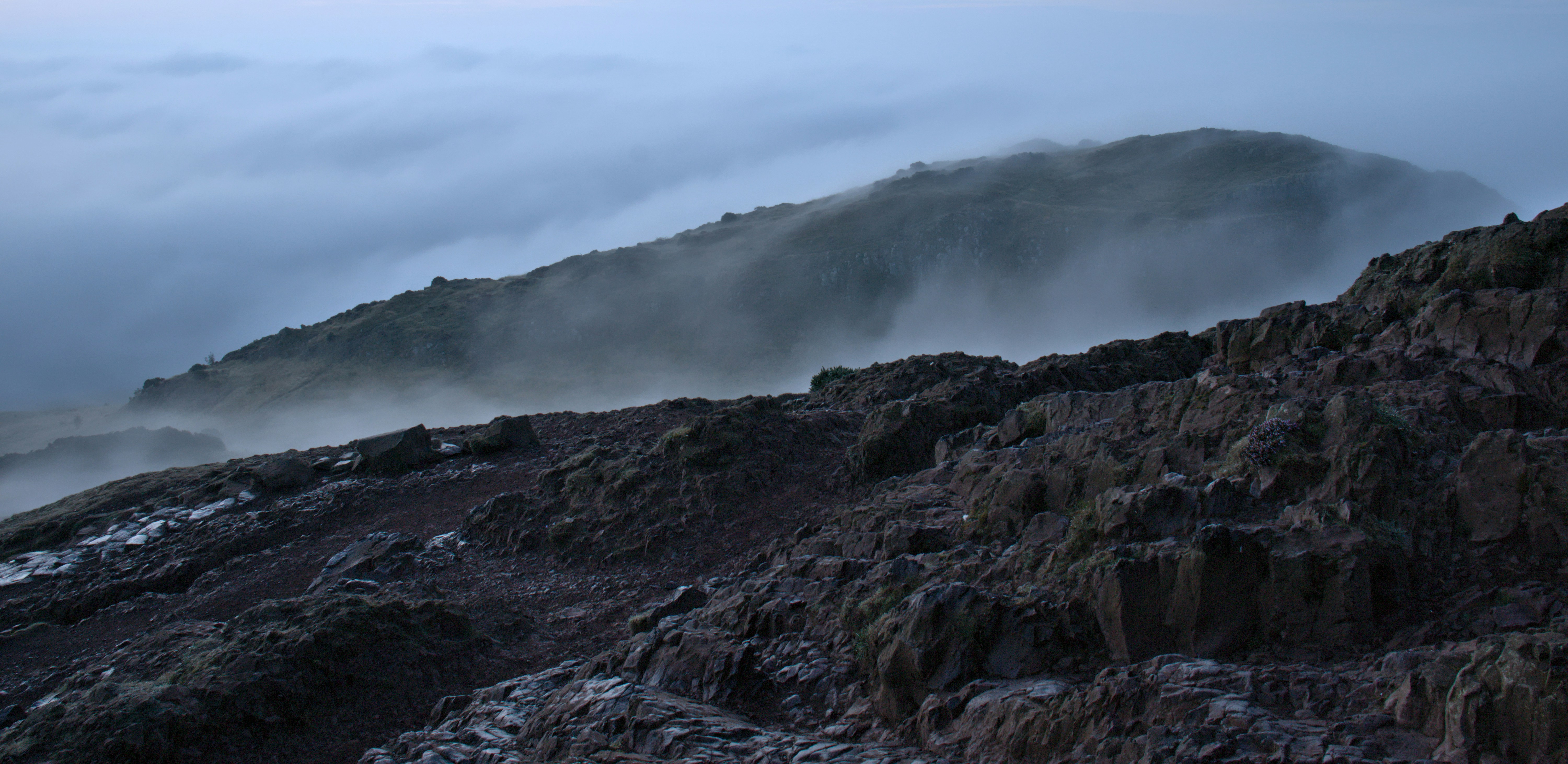 una montaña cubierta de niebla y nubes bajas