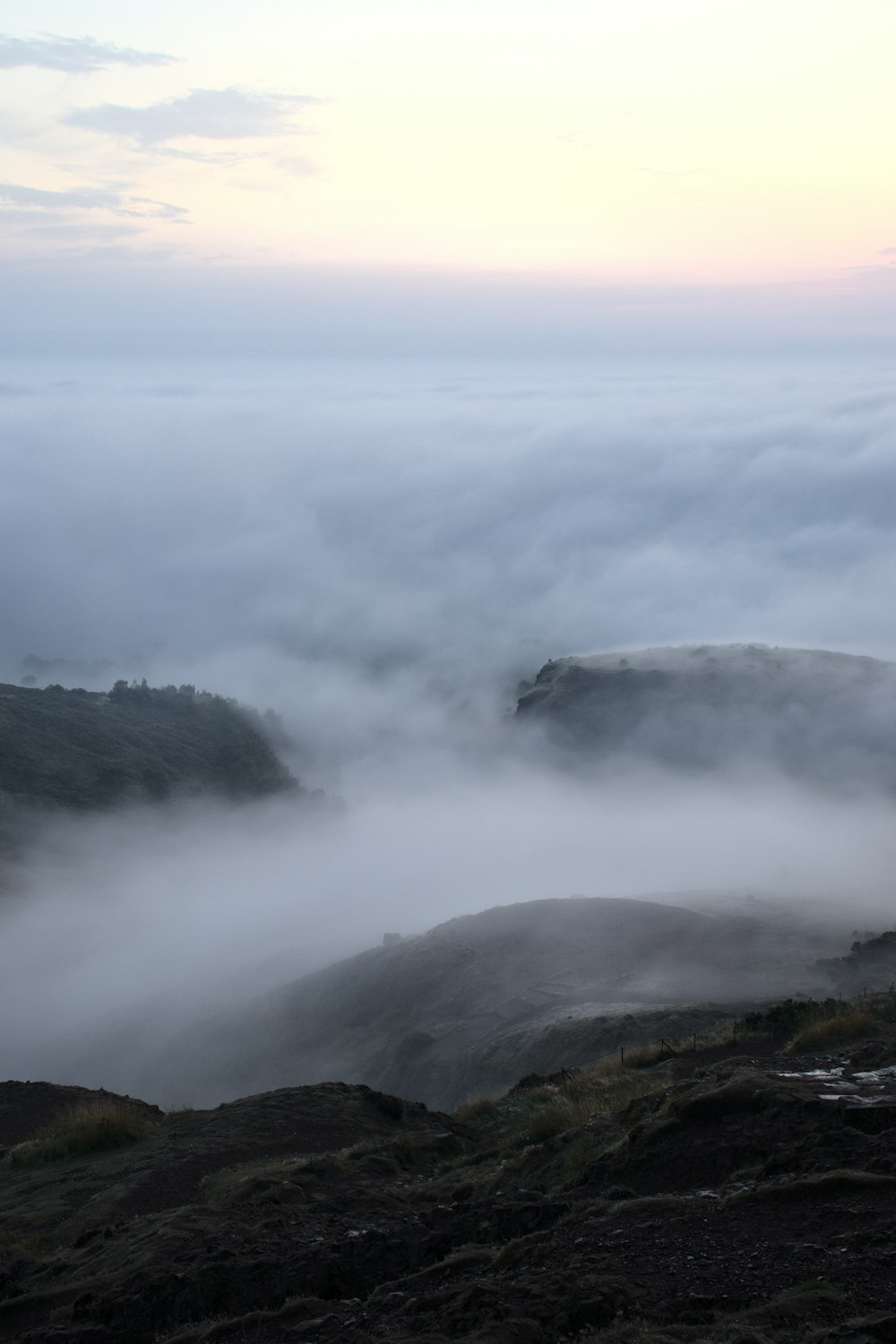 a foggy landscape with a mountain in the distance