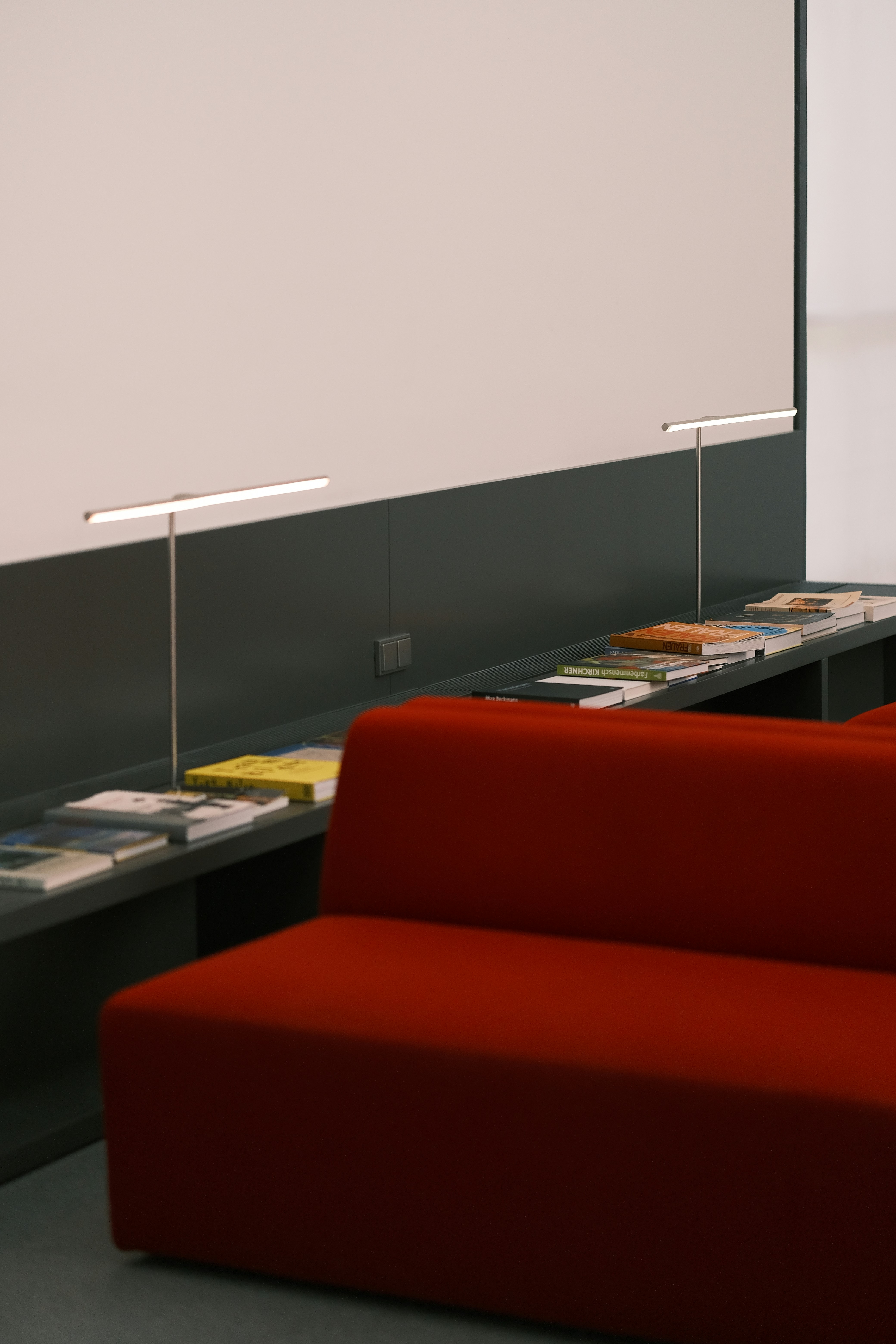 a red couch sitting next to a white wall