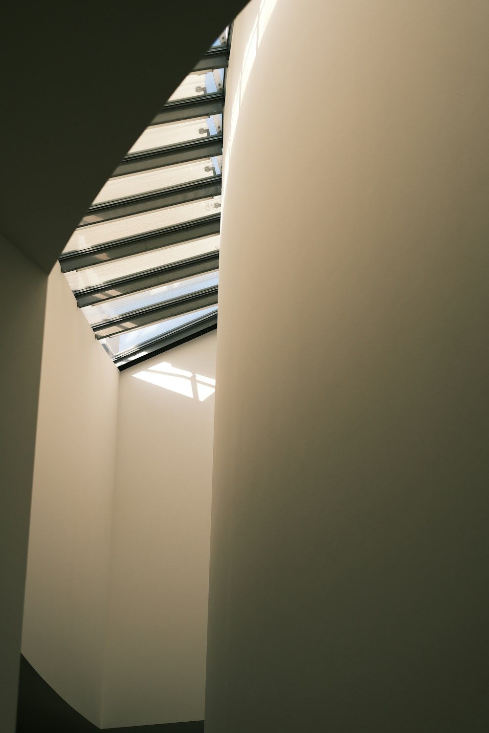 a white wall with a window and a skylight