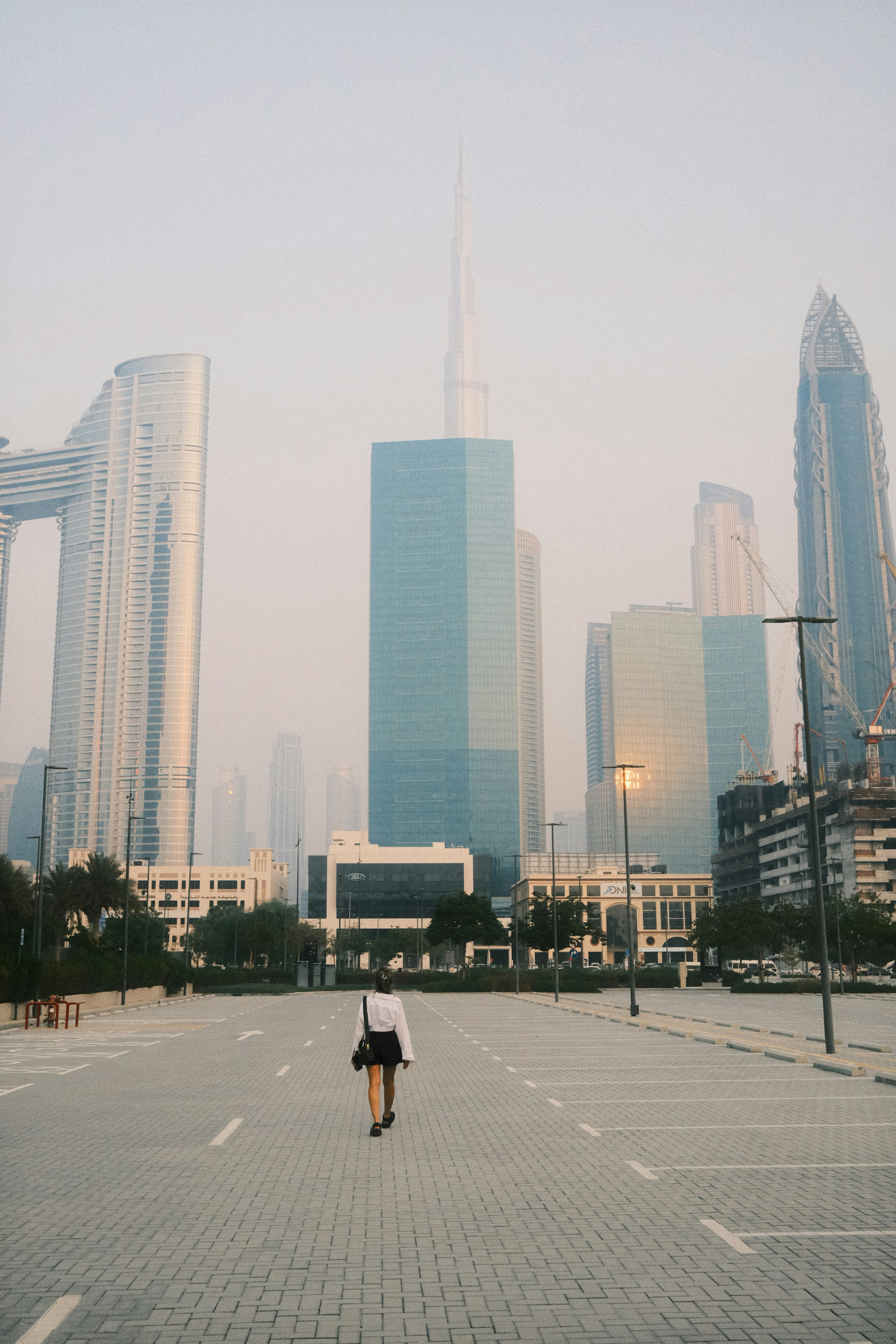 a person walking down a street in front of tall buildings