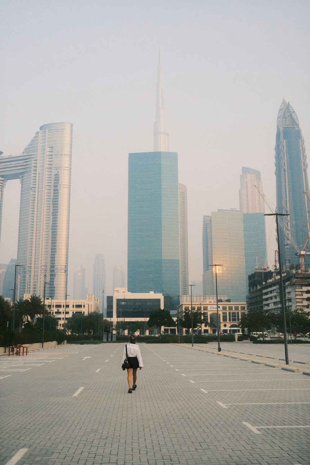 a person walking down a street in front of tall buildings