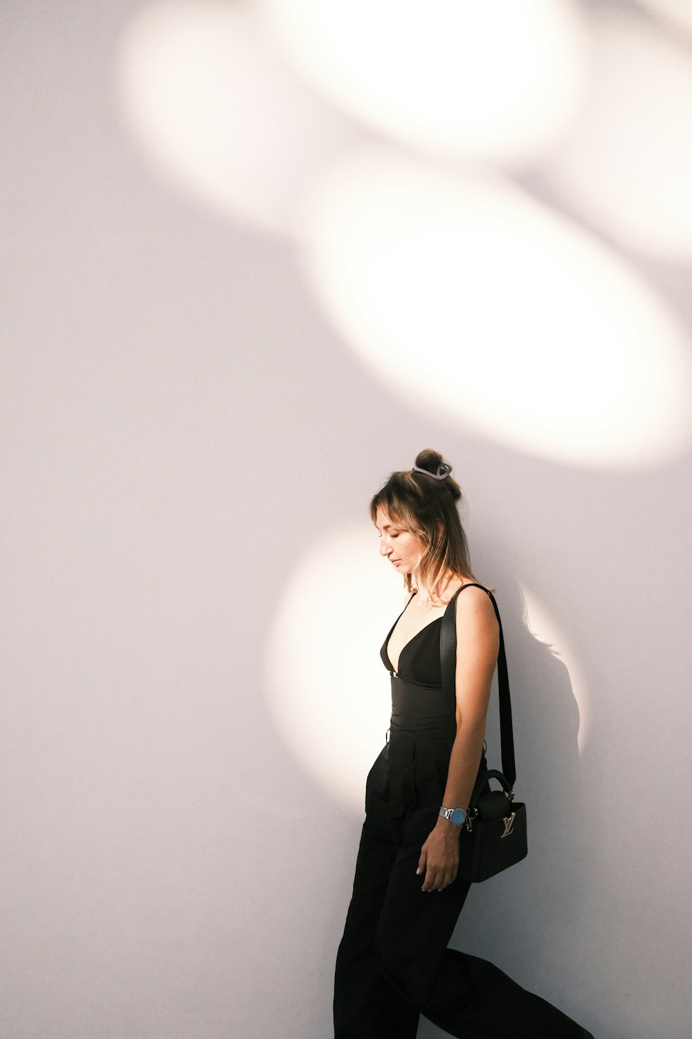 a woman standing in front of a white wall