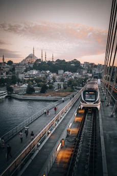 A sleek modern train crossing a bridge at sunset, symbolizing Franco-Moroccan railway cooperation.
