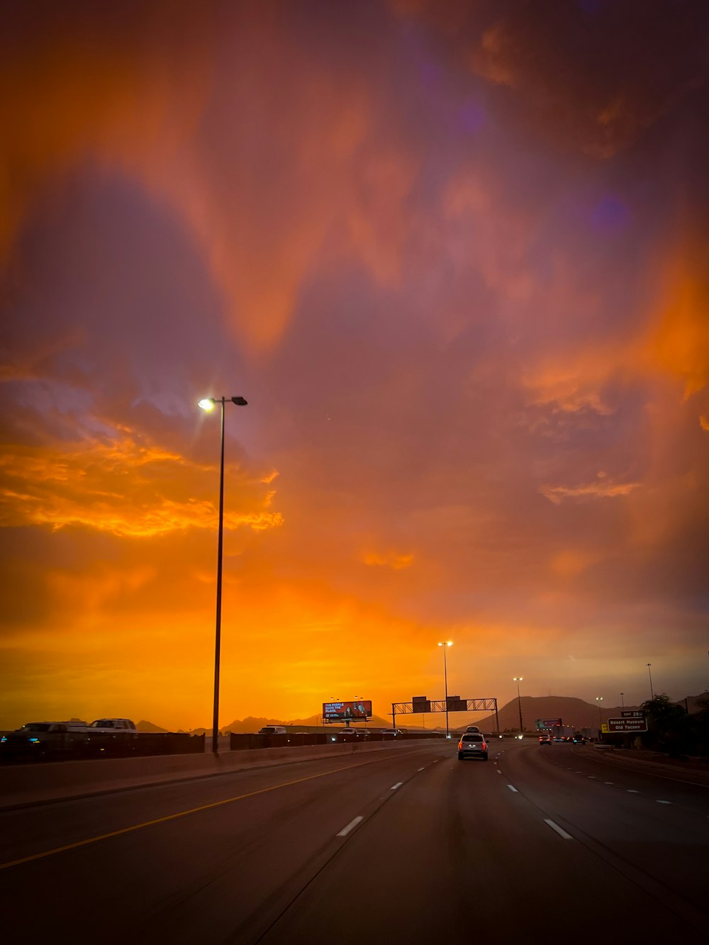 a car driving down a highway under a cloudy sky