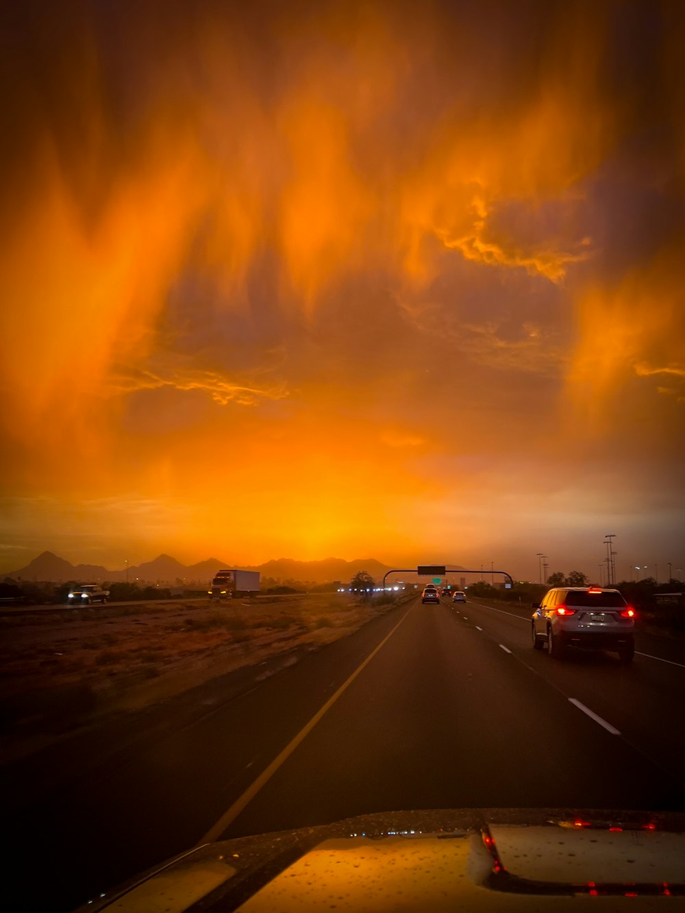 a car driving down a highway under a cloudy sky