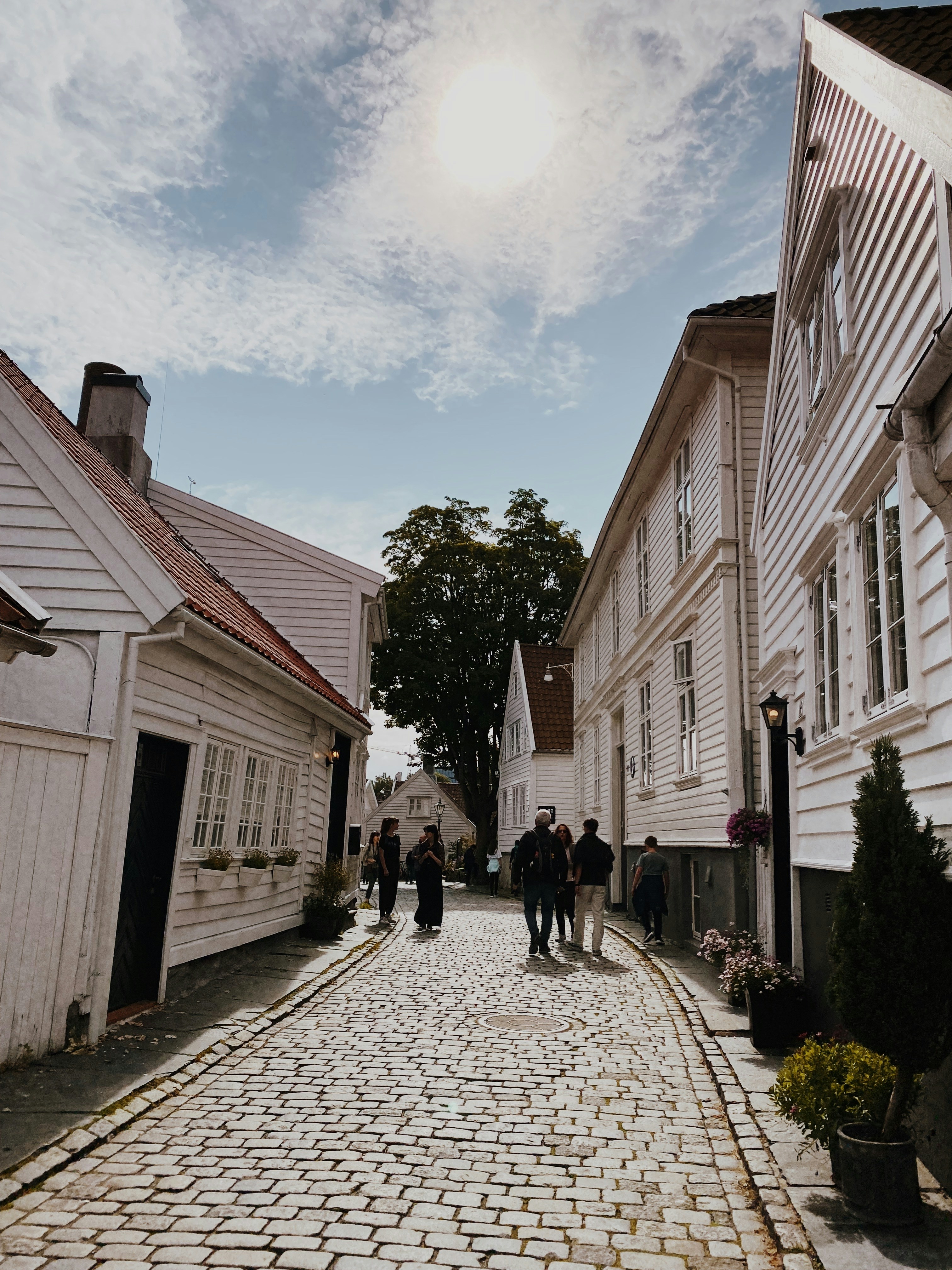 a group of people walking down a cobblestone street