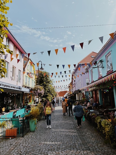 A sunlit cobblestone street lined with colorful, quaint cafes inviting travelers to pause and savor the moment.