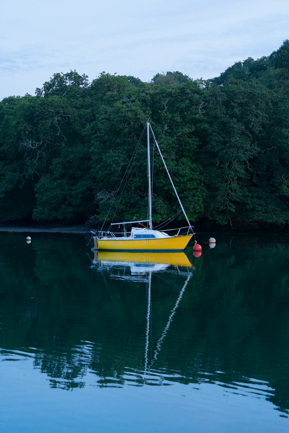 a yellow boat floating on top of a body of water