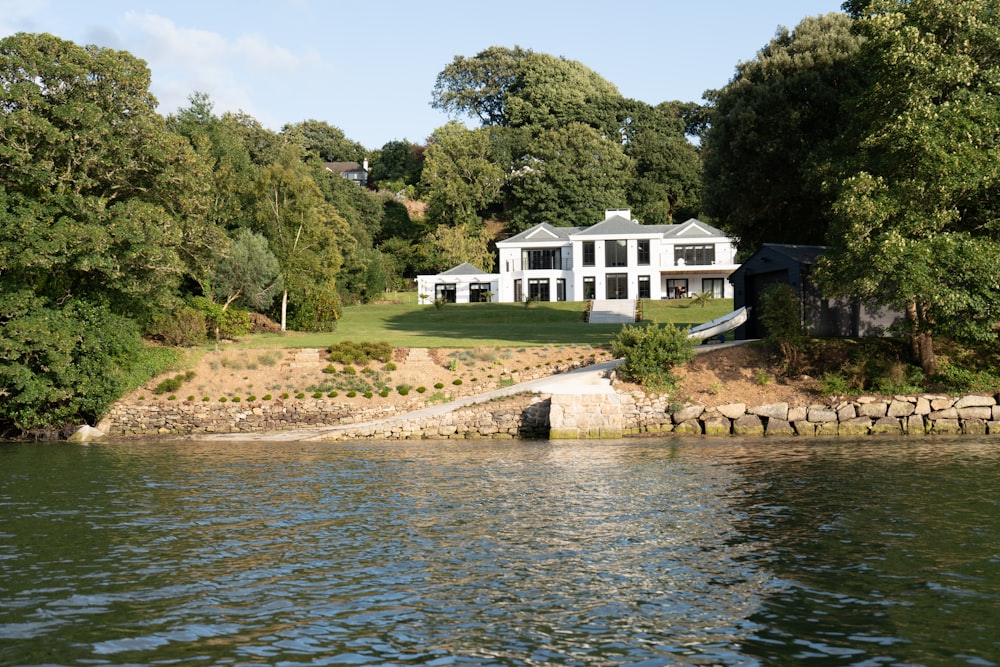 a large white house sitting on top of a lush green hillside