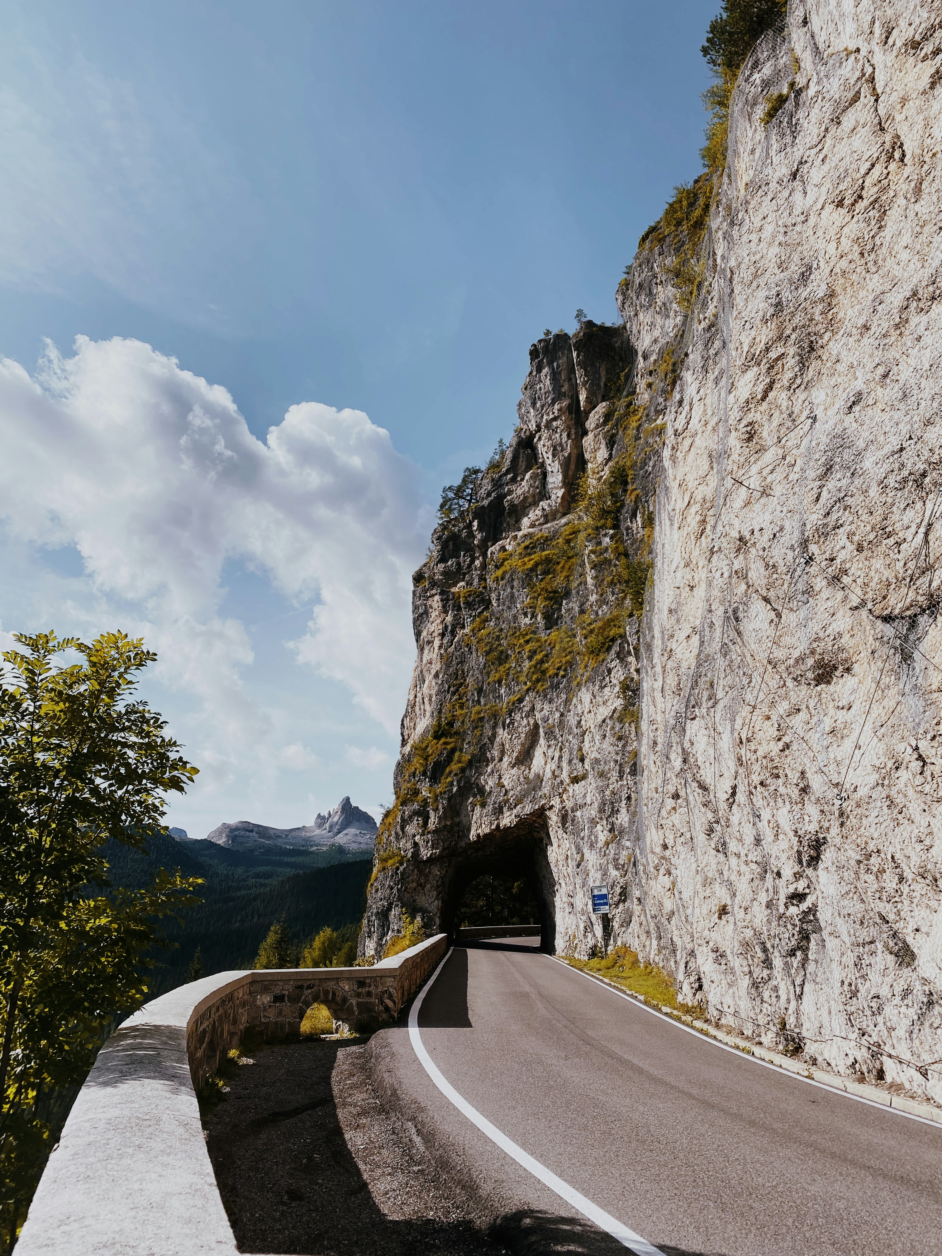 a road going into a tunnel in the side of a mountain