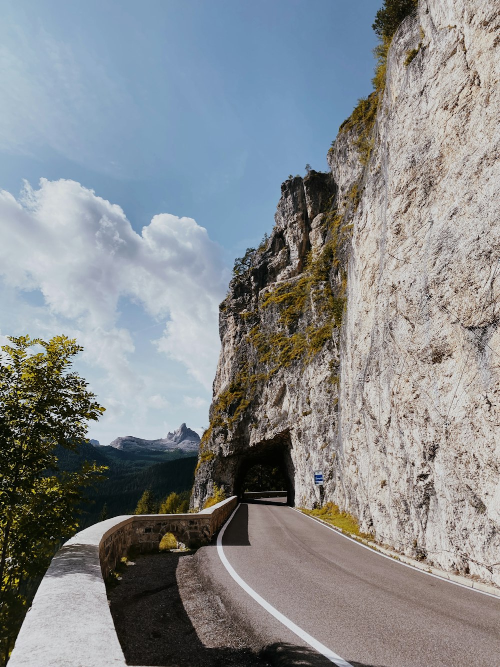 a road going into a tunnel in the side of a mountain