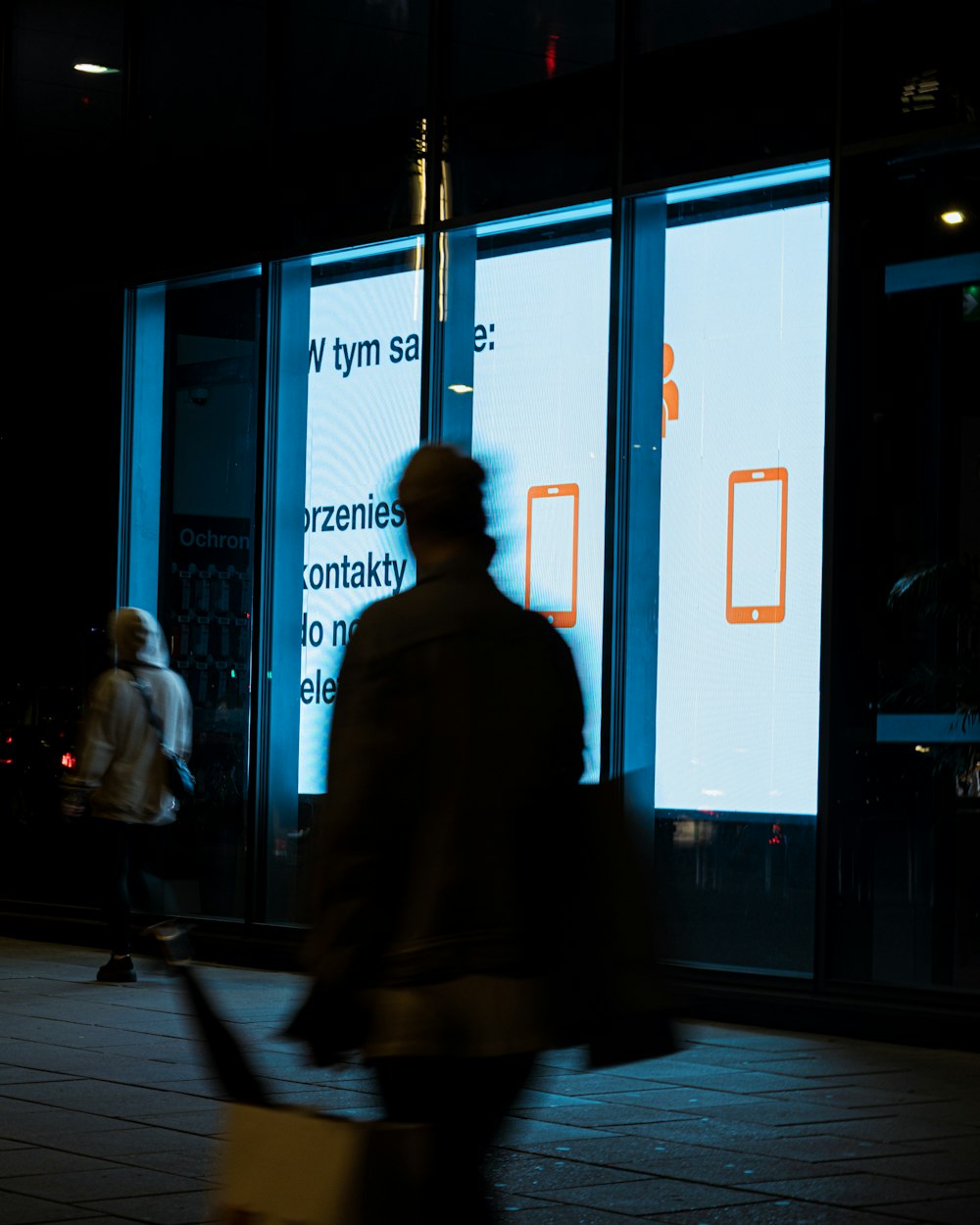 a man walking down a street at night