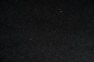 a close up of a black surface with a white object in the middle of it