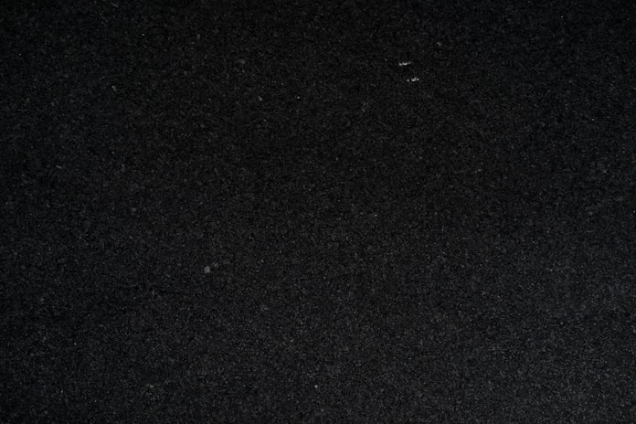 a close up of a black surface with a white object in the middle of it