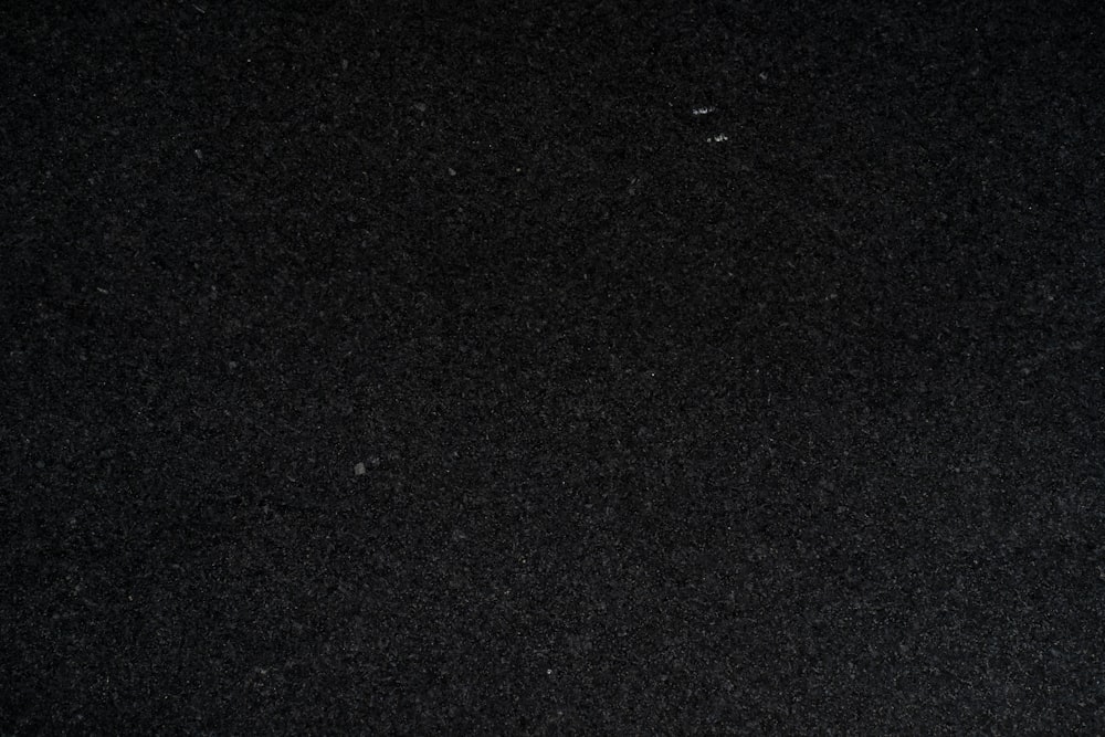 Un primer plano de una superficie negra con un objeto blanco en el medio de ella