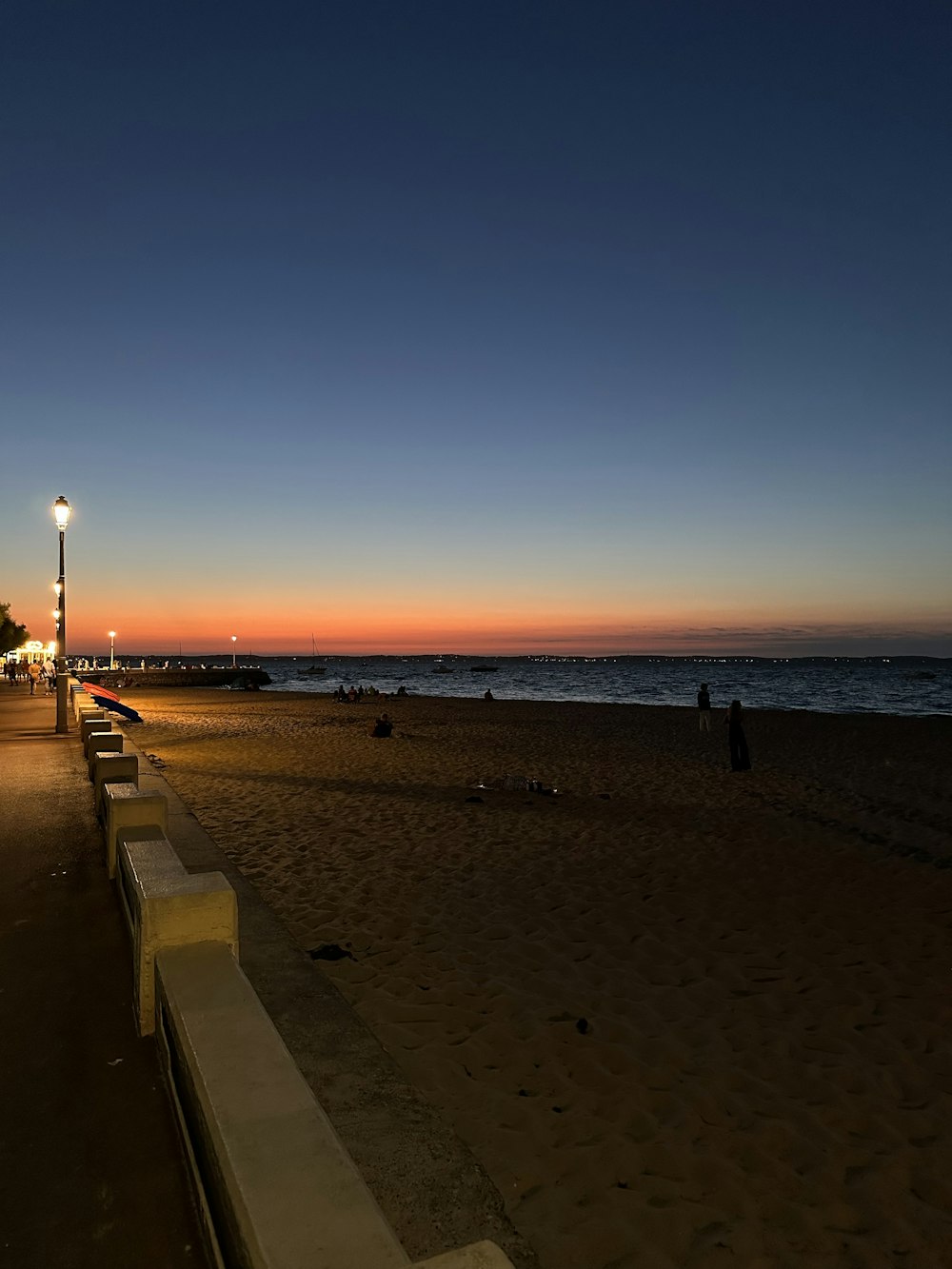 a bench sitting on top of a sandy beach next to the ocean