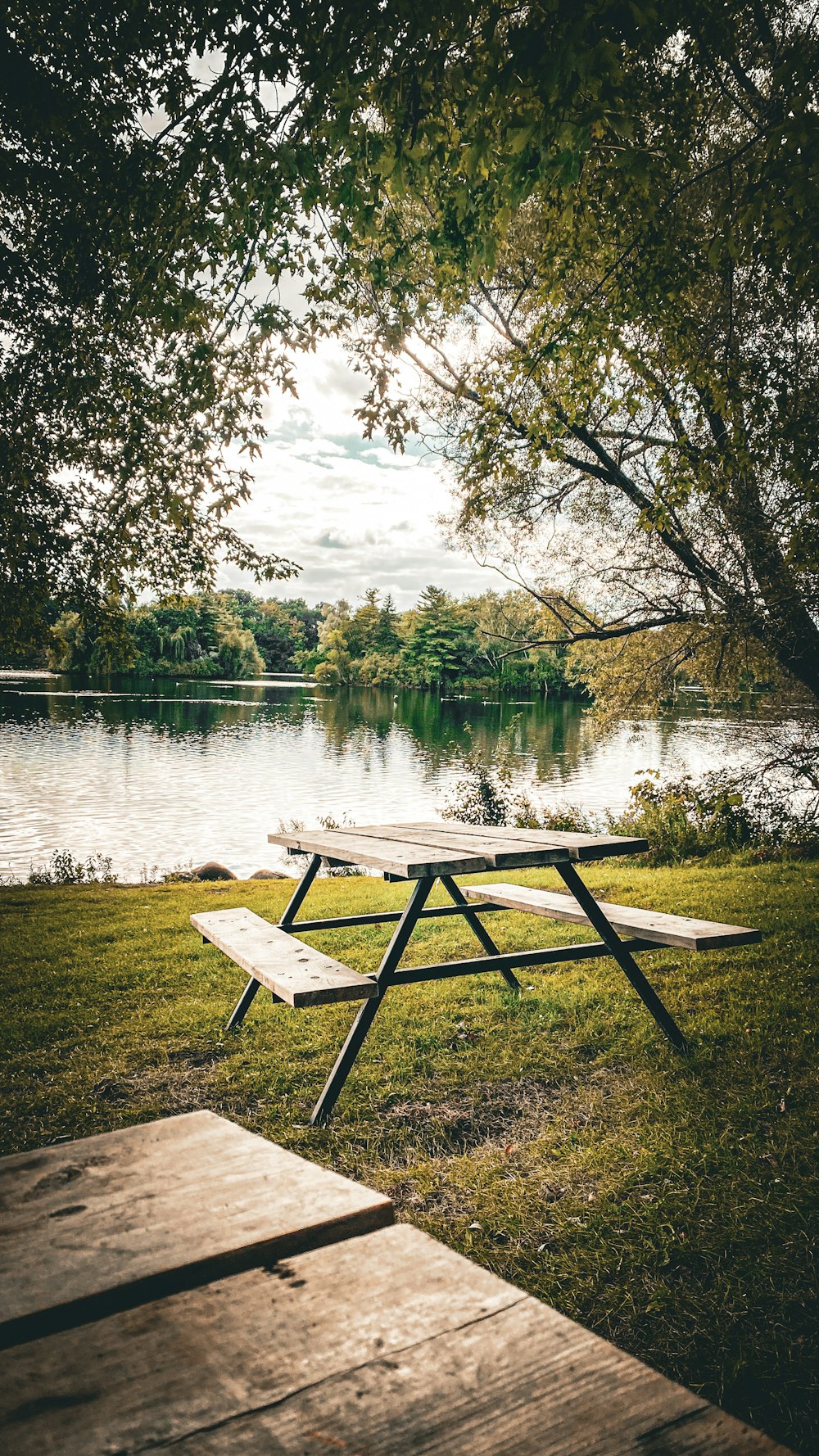 a picnic table sitting next to a lake