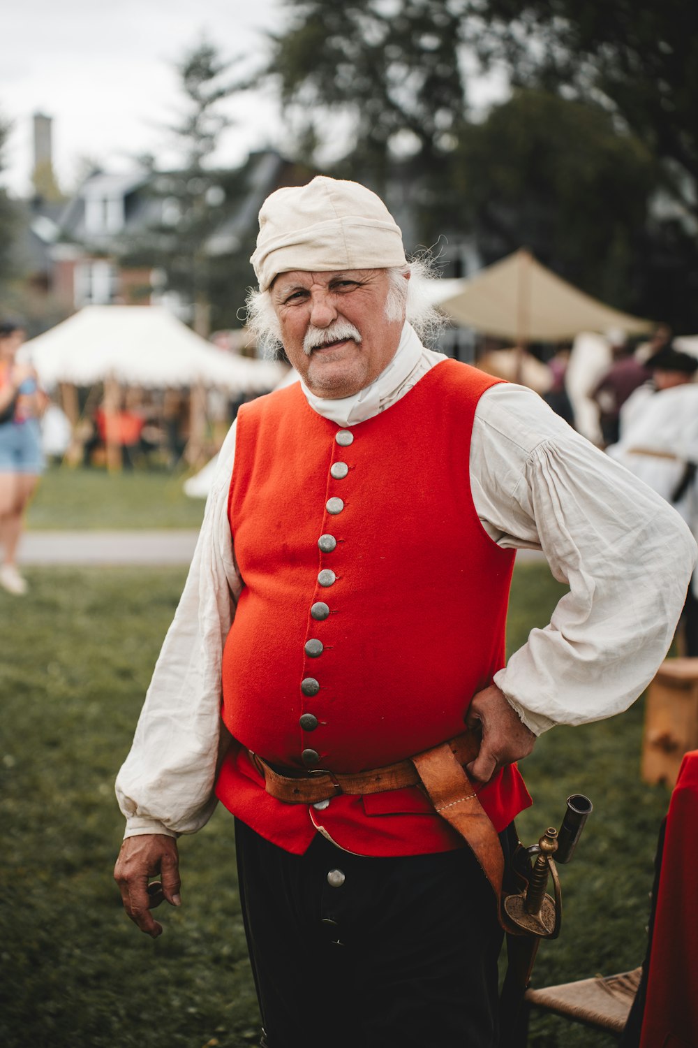 Un vecchio con un giubbotto rosso e un turbante bianco