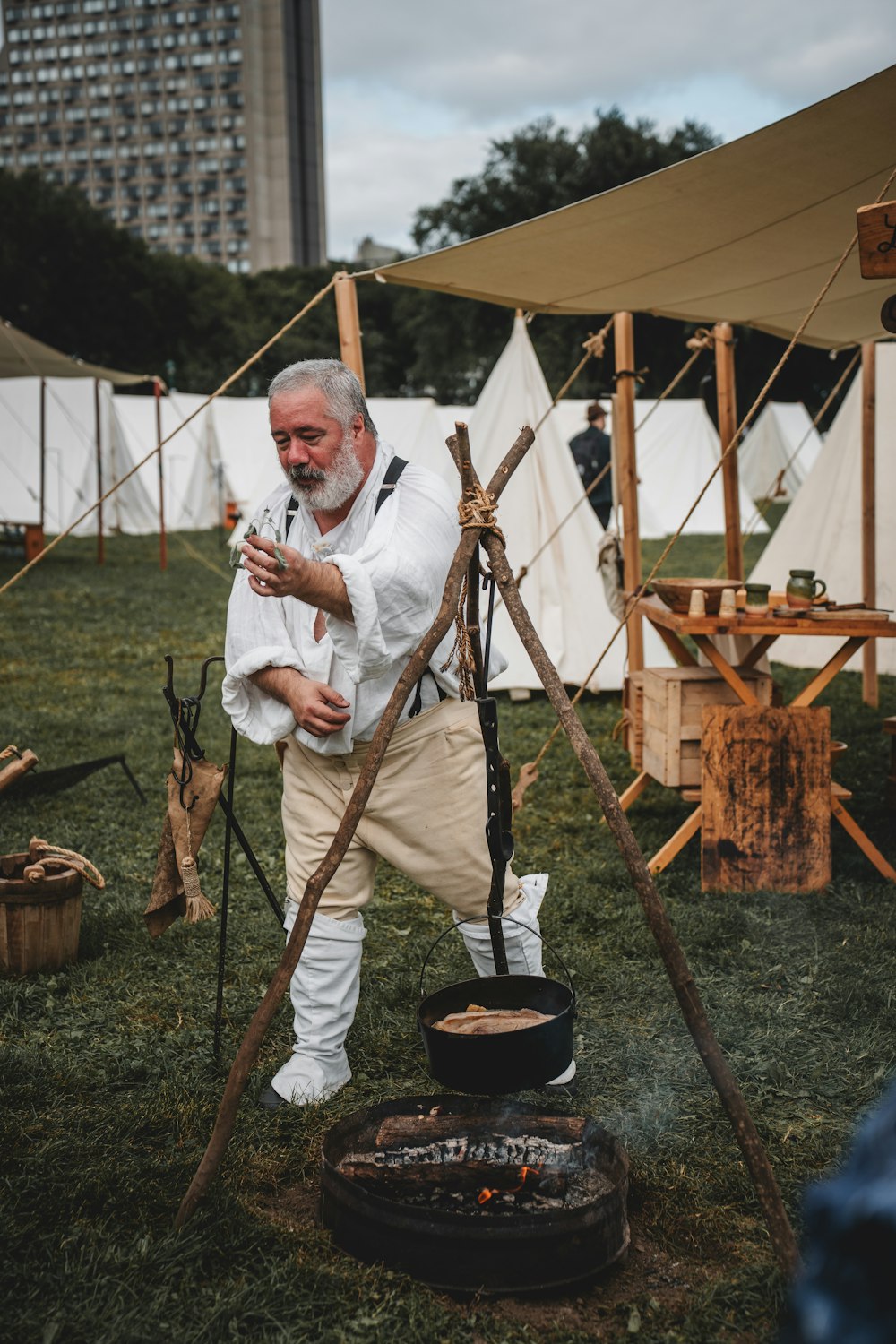 a man standing next to a fire in a field