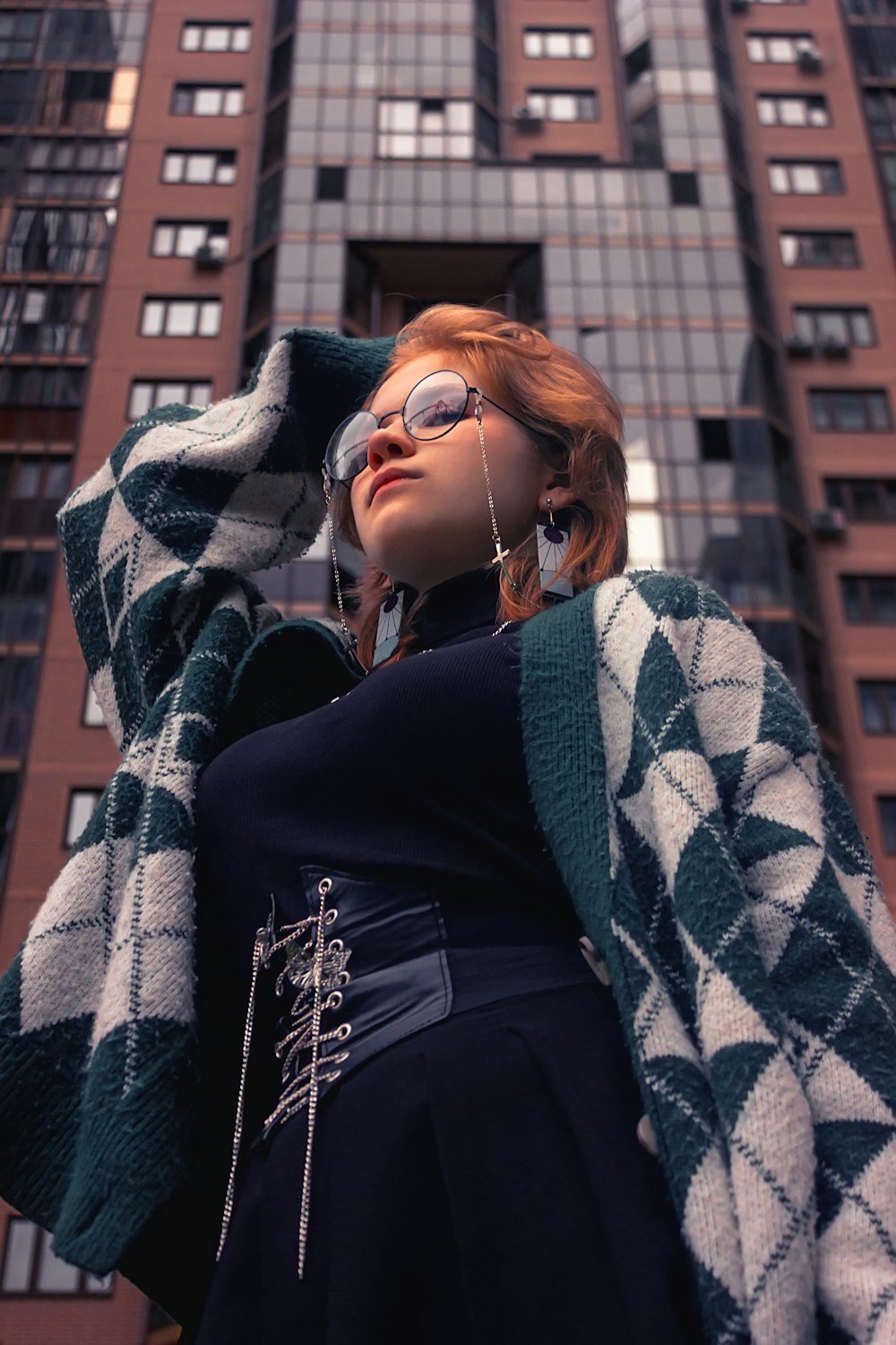 a woman in a black dress and a green and white checkered coat