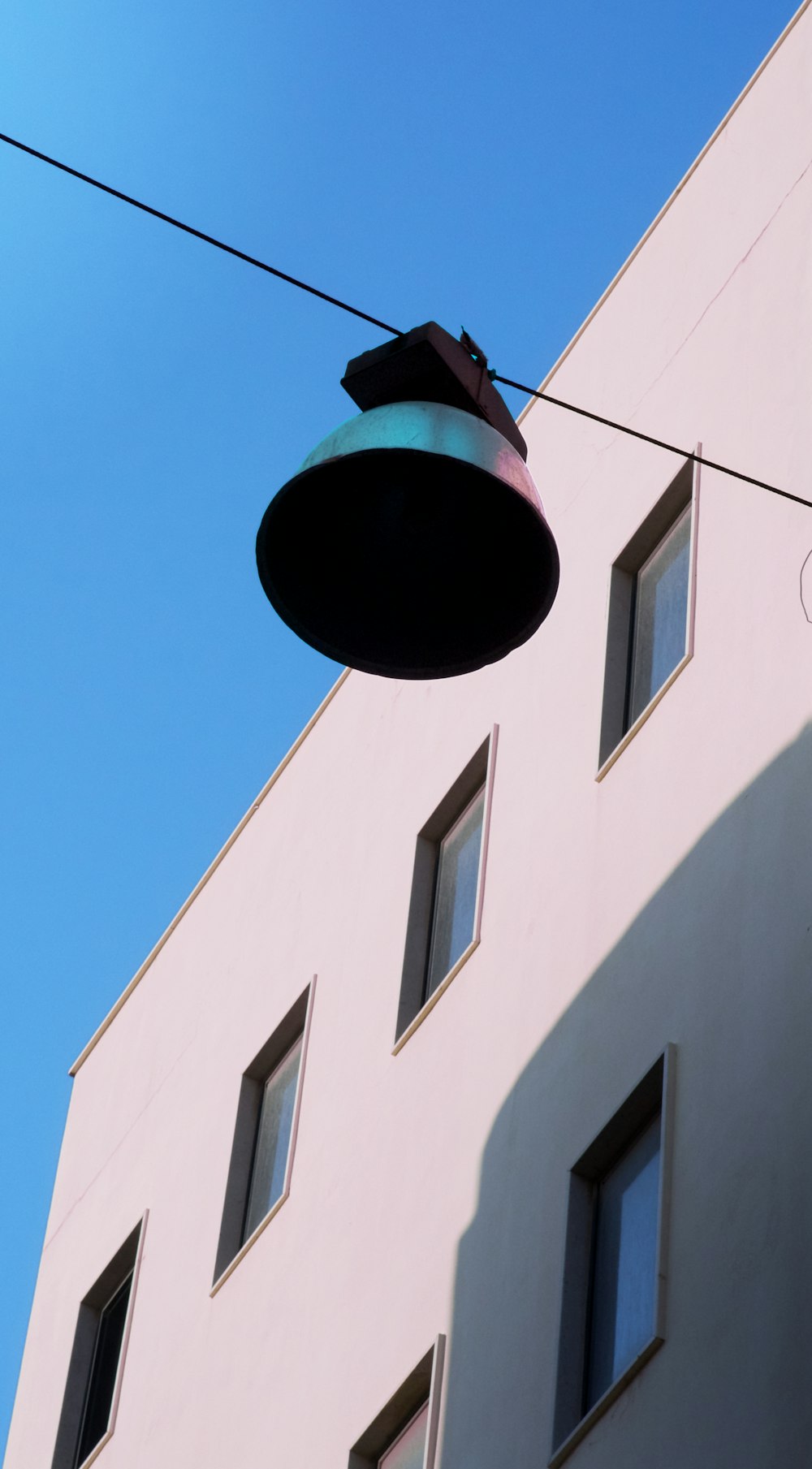 a street light hanging from a wire next to a building