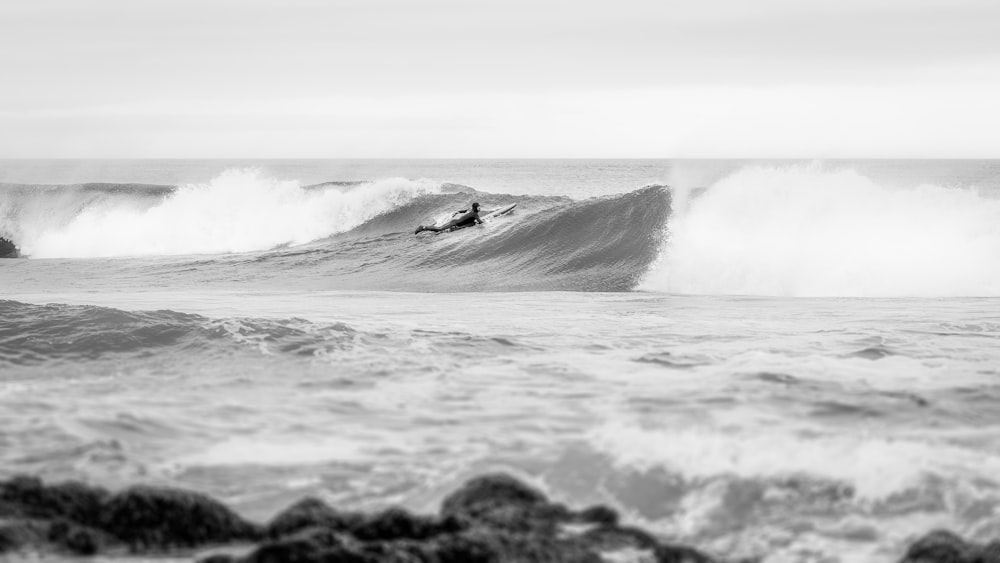 a man riding a wave on top of a surfboard