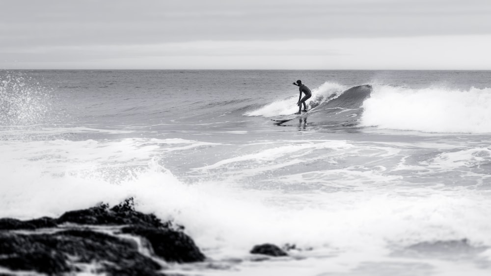 a man riding a wave on top of a surfboard