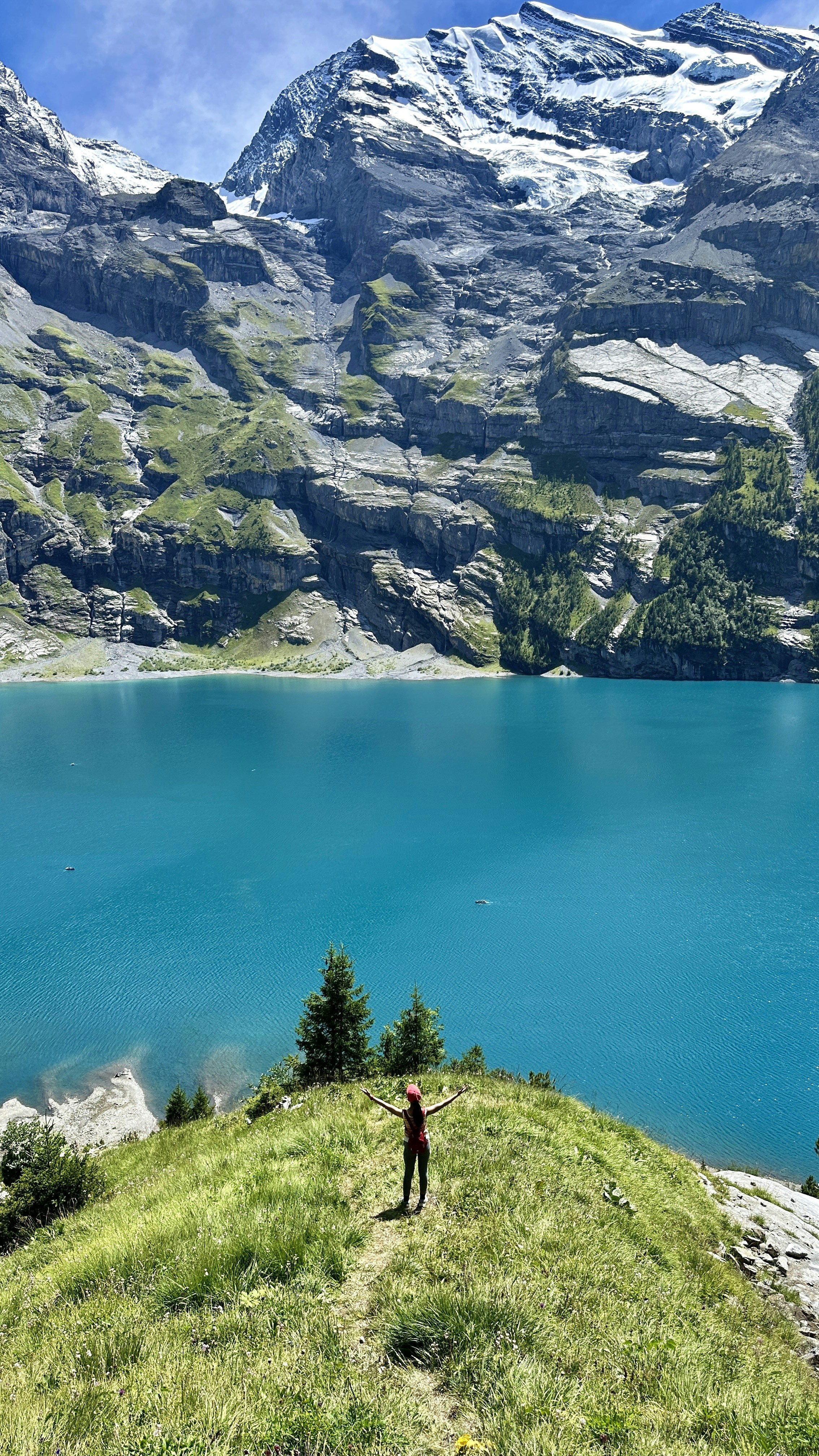 a man standing on top of a lush green hillside