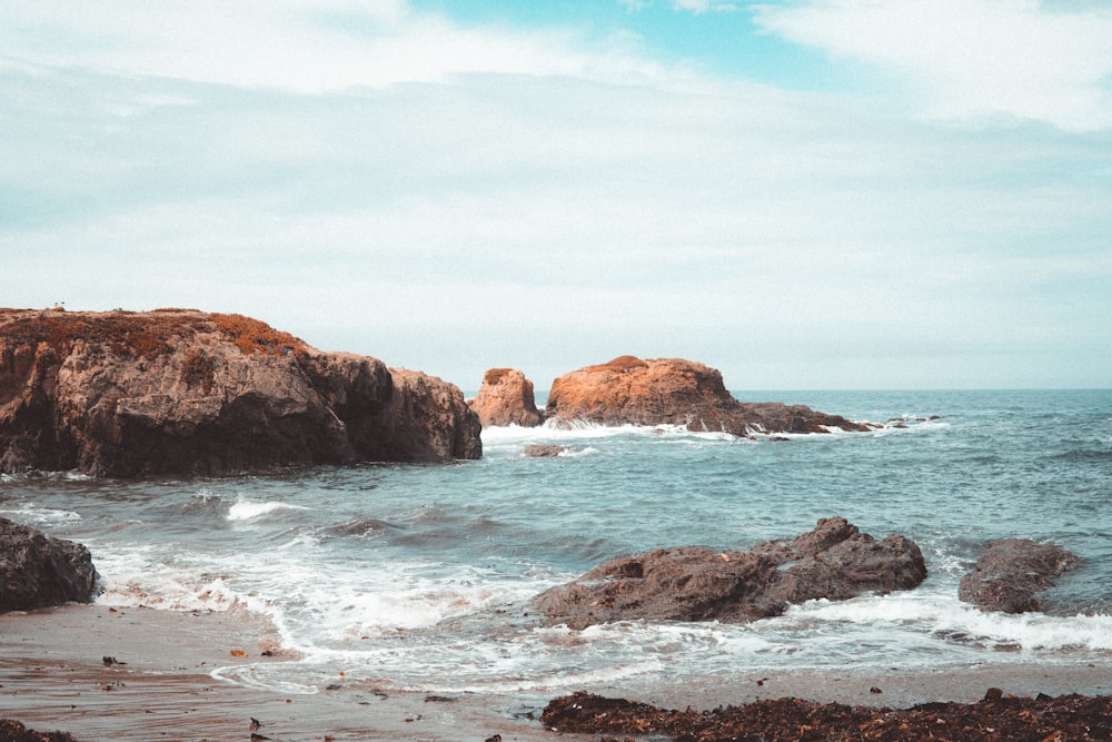 a couple of large rocks sitting on top of a beach