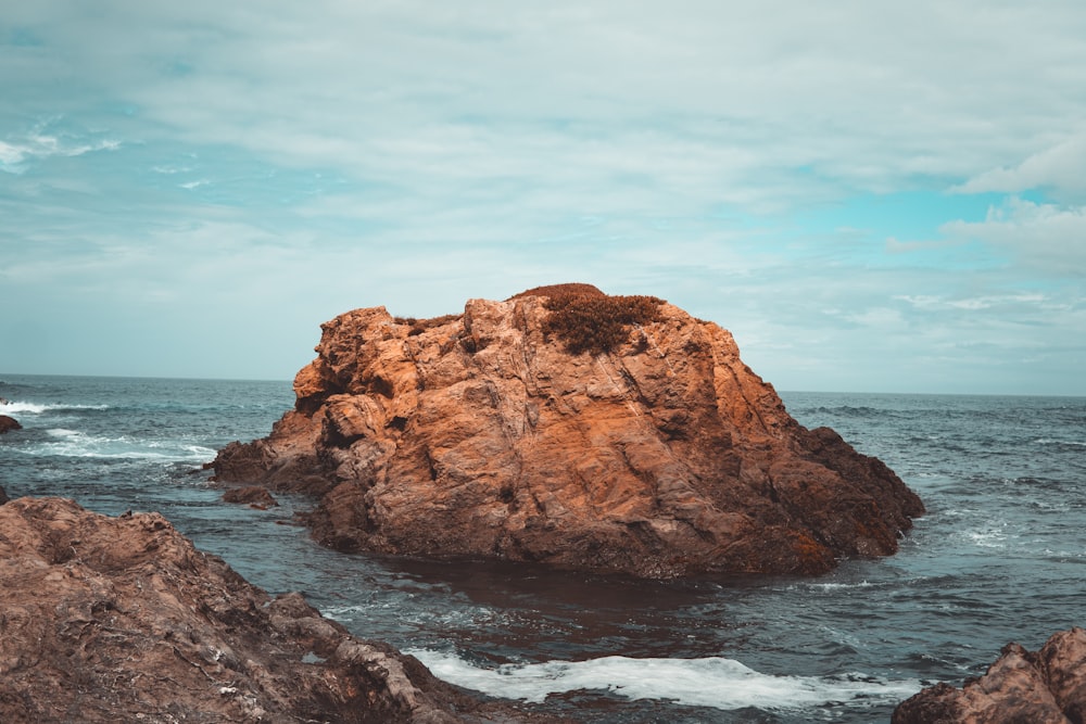 a large rock in the middle of the ocean