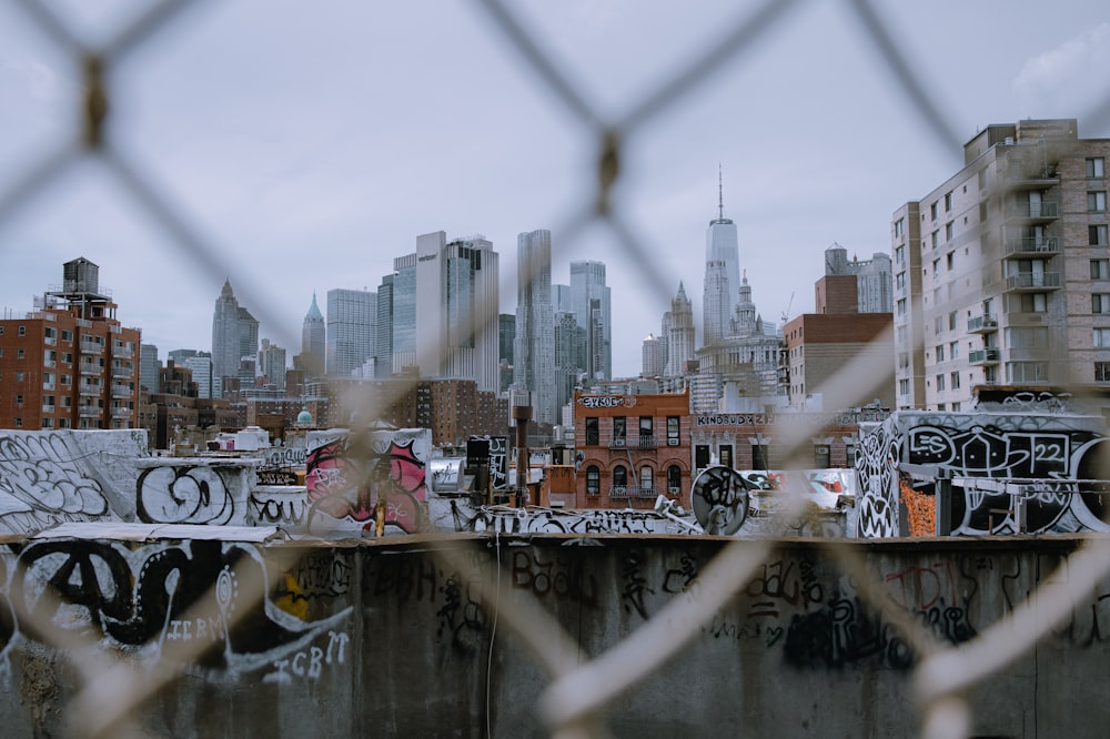 a view of a city through a chain link fence