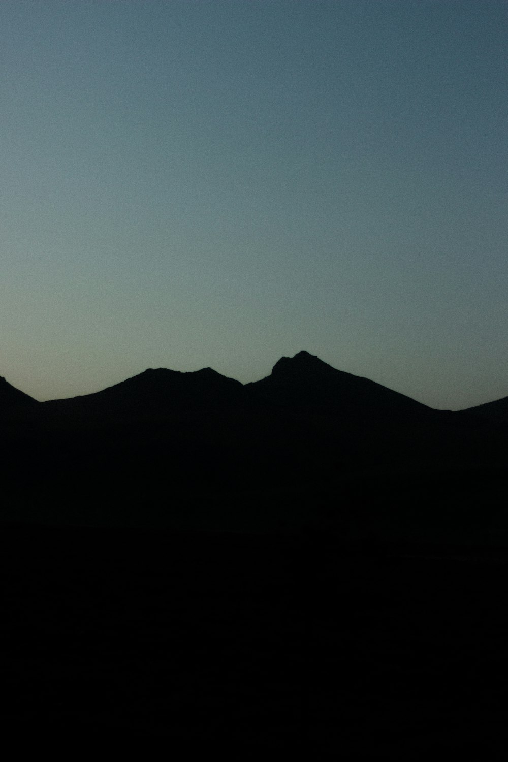 Die Silhouette einer Bergkette vor blauem Himmel