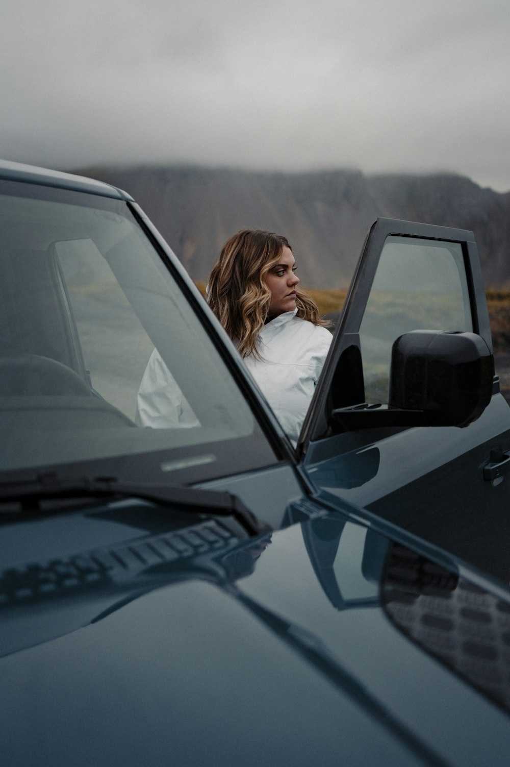 a woman sitting in the drivers seat of a car