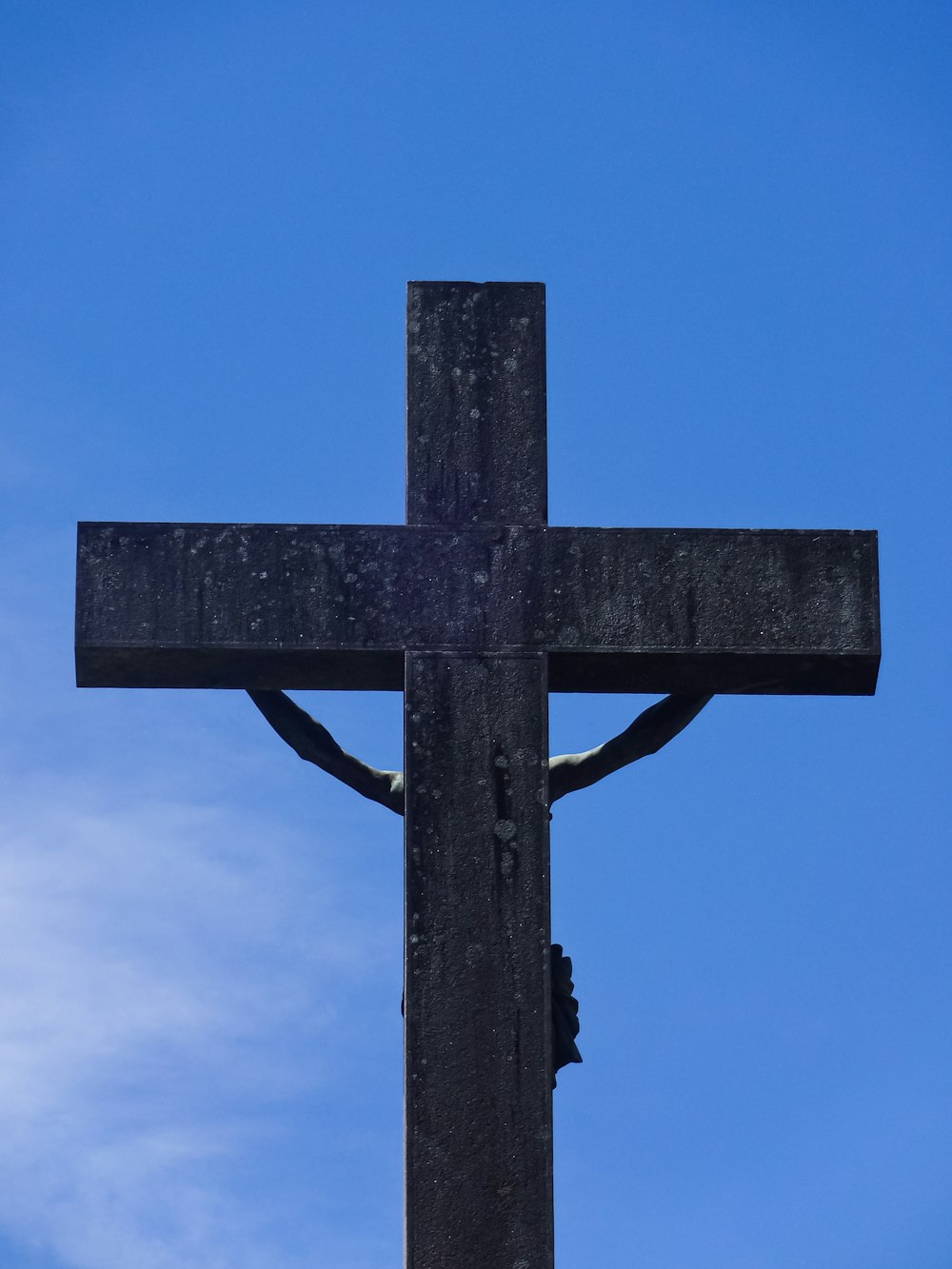 a large wooden cross with a sky background