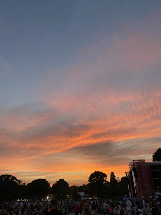 An energetic crowd listening to Prakash during a political rally at sunset.