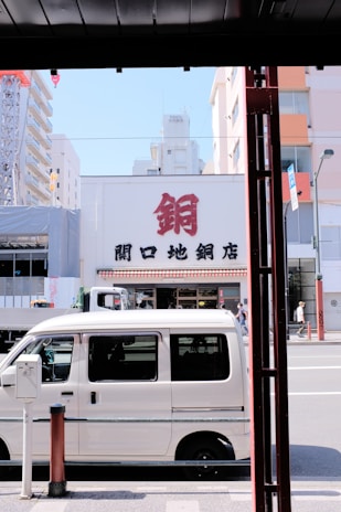 A modern accessible transport van parked in front of a city building.