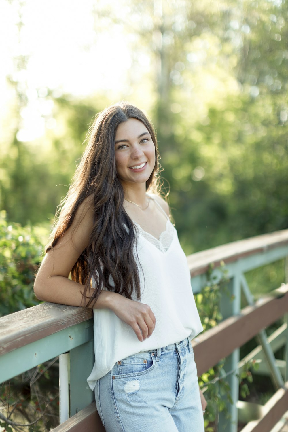 a beautiful young woman standing on a bridge