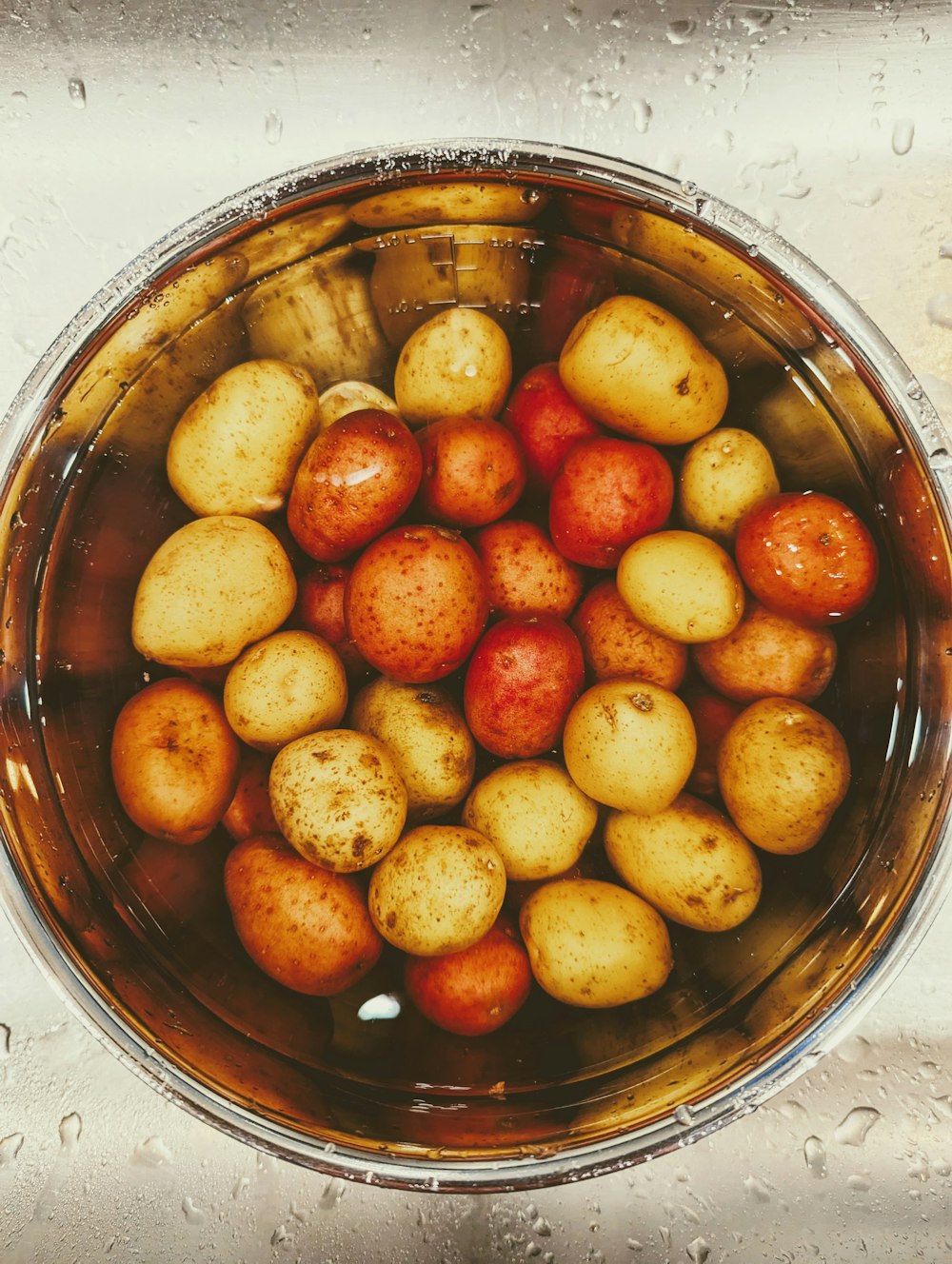 a bowl full of potatoes sitting on top of a counter