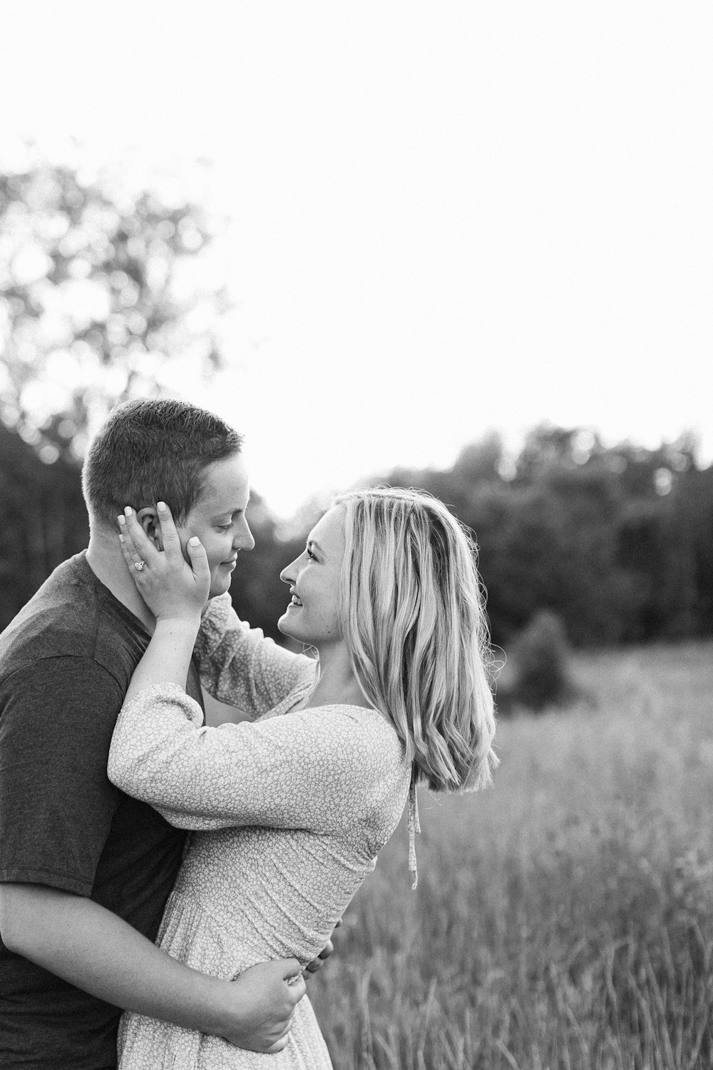 a man and a woman standing in a field of tall grass