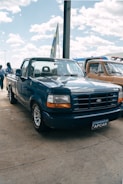 A blue pickup truck parked on a sunny lot.