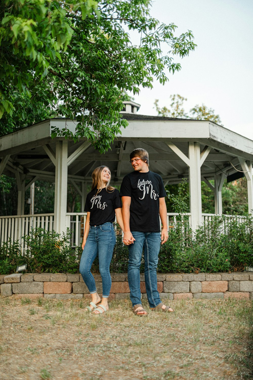 a man and a woman standing in front of a gazebo