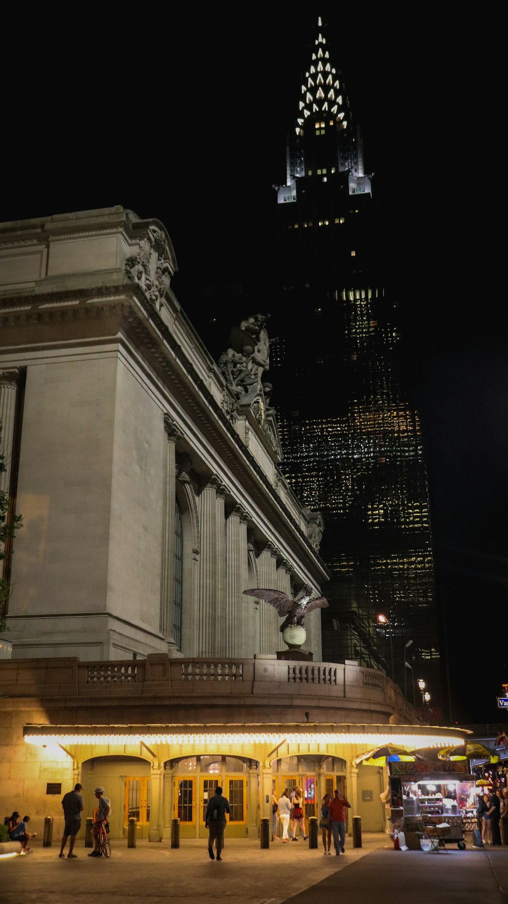 people are standing outside of a building at night