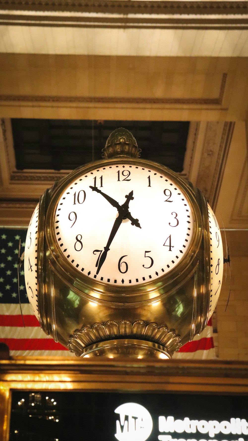 a large clock hanging from the ceiling of a building